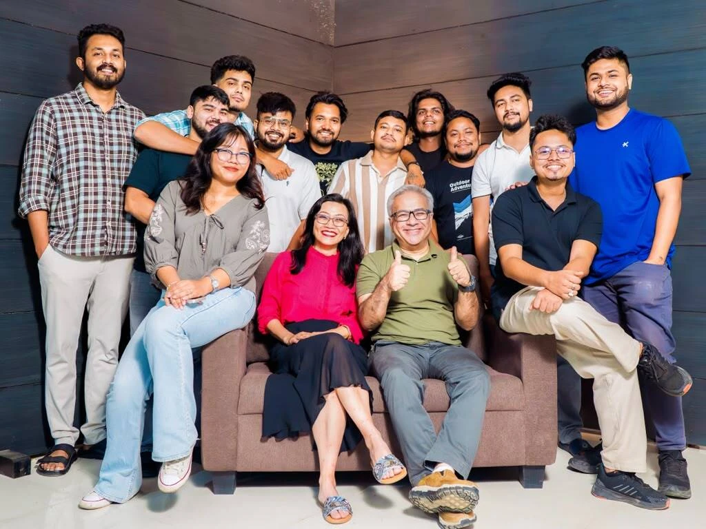 The TrueLeap team, smiling together around a sofa